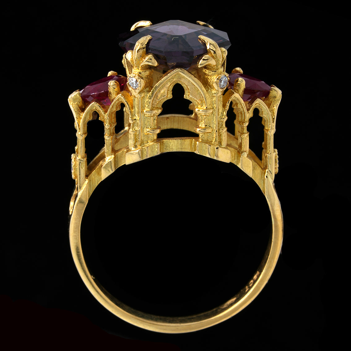 Gold ring with cathedral inspired  design with a spinel, rubies and diamonds on a black background