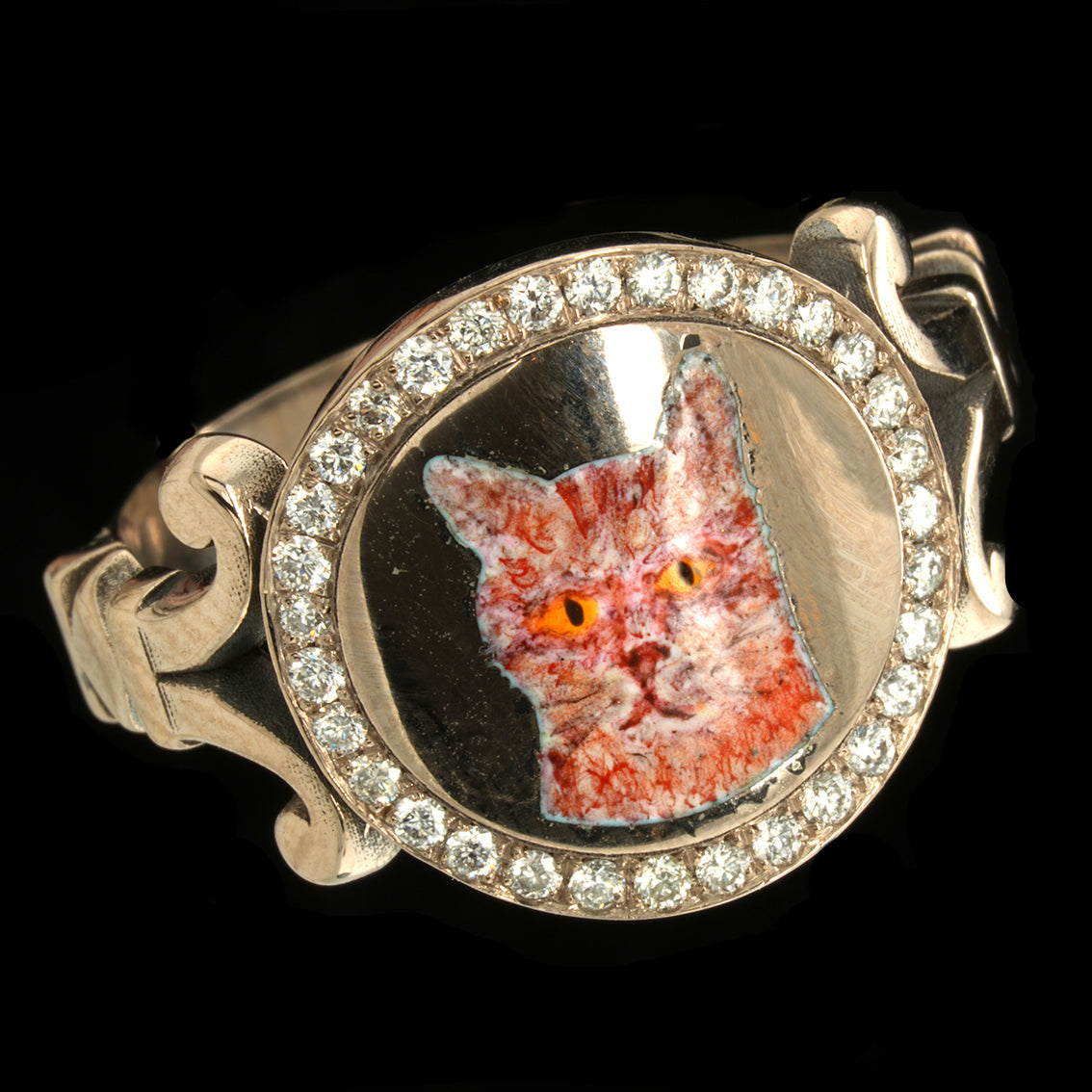Ring with a cat face design and diamond accents on a black background