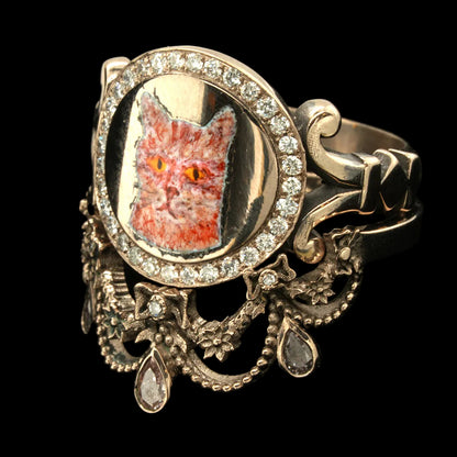Gold ring with a cat portrait and diamond accents on a black background