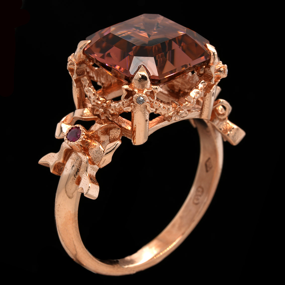 Rose gold ring with a large peach tourmaline gemstone on a black background