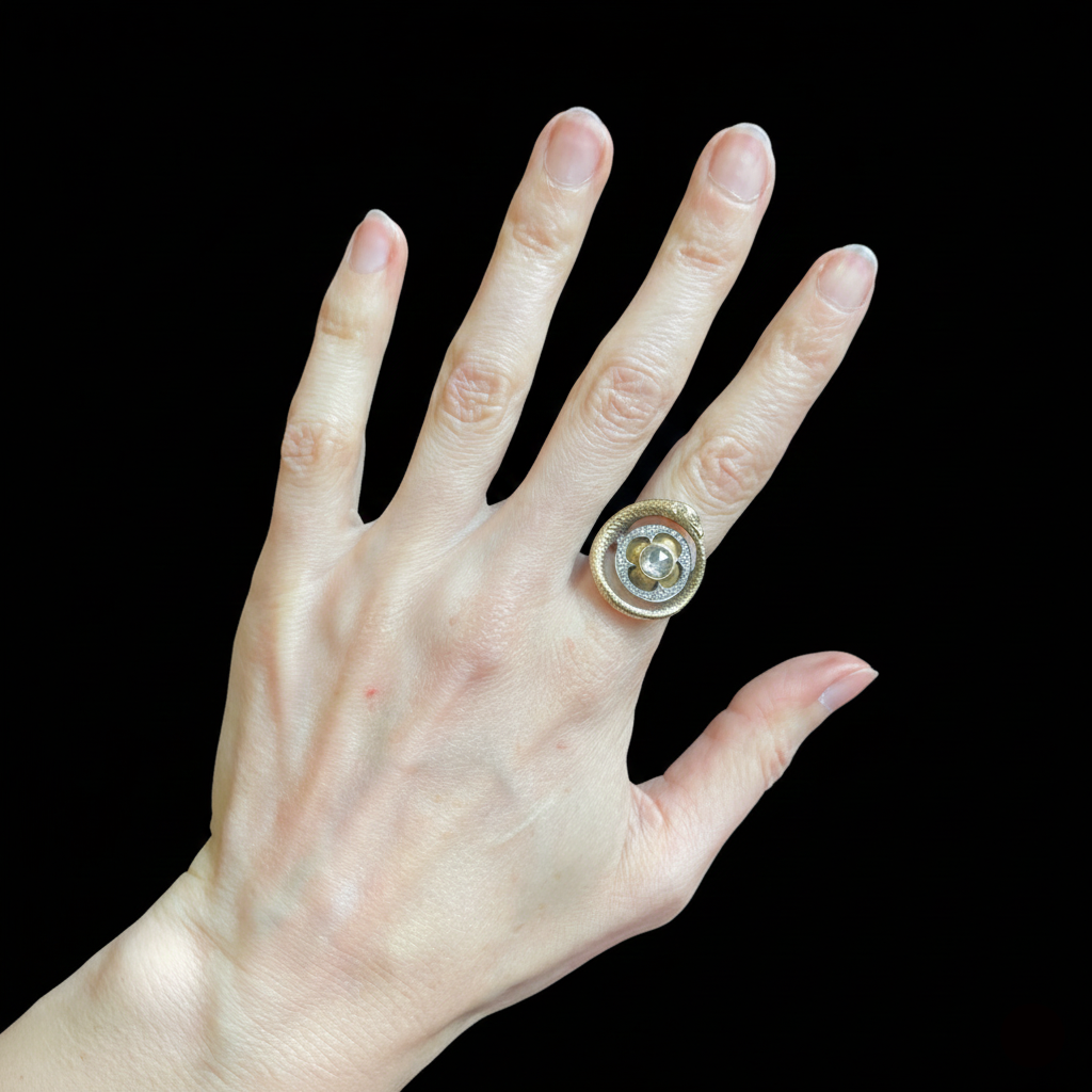 Hand wearing a gold snake ring with a diamond on a black background