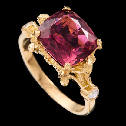 Gold ring with a pink tourmaline on a black background