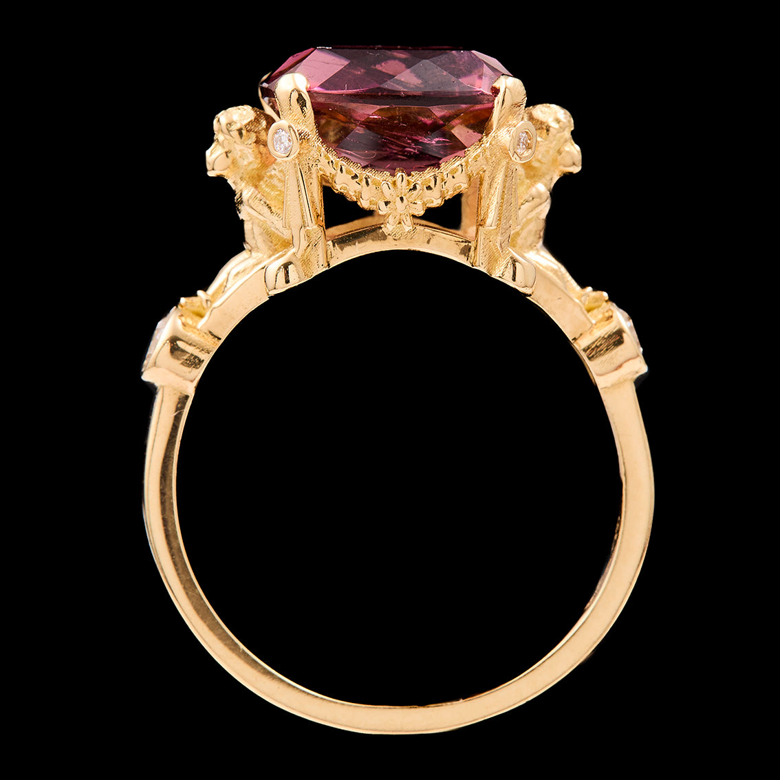 Gold ring with a large pink tourmaline on a black background