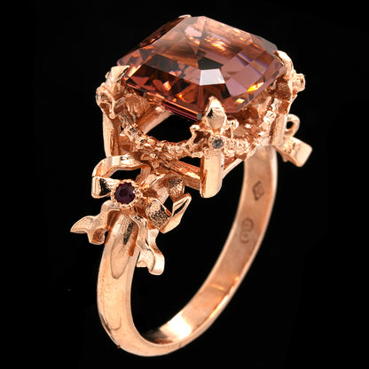 Rose gold ring with a large peachy ink tourmaline gemstone on a black background