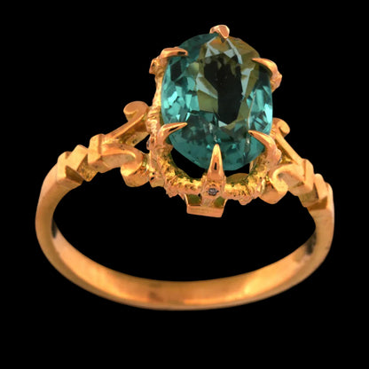 Gold ring with a blue tourmaline gemstone on a black background