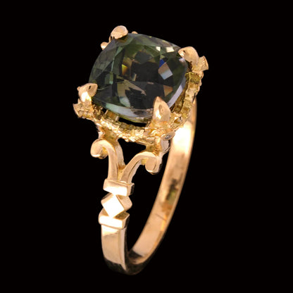 Gold ring with a green tourmaline gemstone on a black background