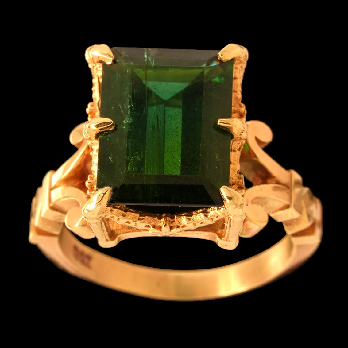 Gold ring with a tourmaline gemstone on a black background