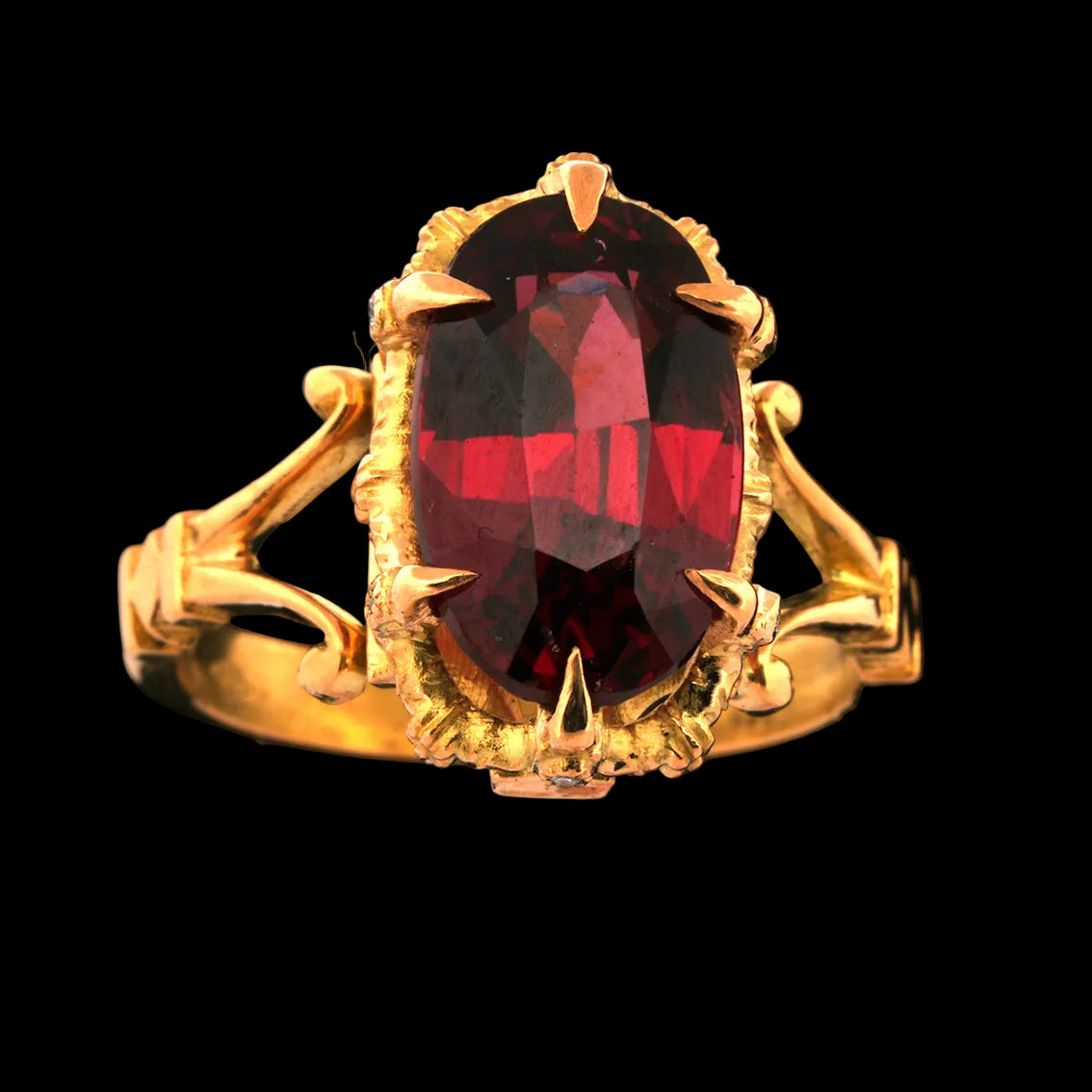 Gold ring with a garnet gemstone on a black background