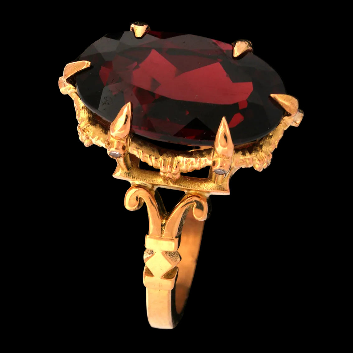 Gold ring with a garnet gemstone on a black background