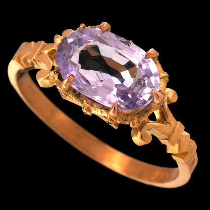gold ring with a lilac sapphire stone 
