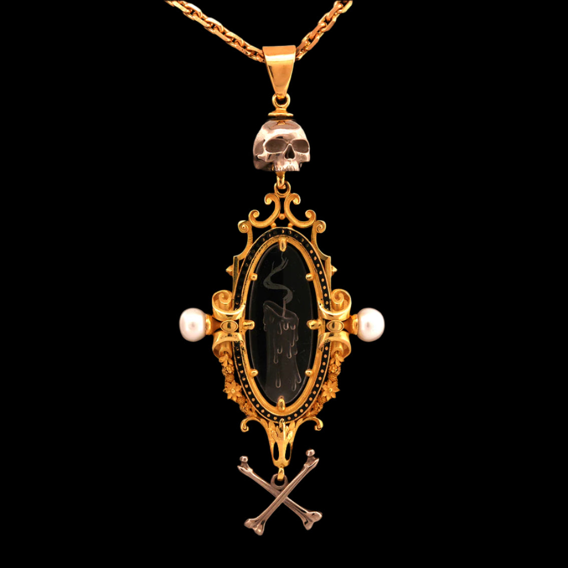 An 18ct yellow gold pendant necklace with a carved intaglio quartz crystal of a snuffed out candle, topped and tailed with a white gold skull and crossbones, suspended from a yellow gold chain.