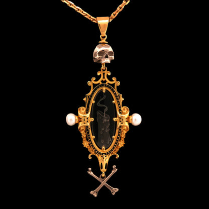 An 18ct yellow gold pendant necklace with a carved intaglio quartz crystal of a snuffed out candle, topped and tailed with a white gold skull and crossbones, suspended from a yellow gold chain.