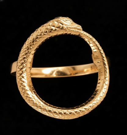 Gold ring with snake design on a black background