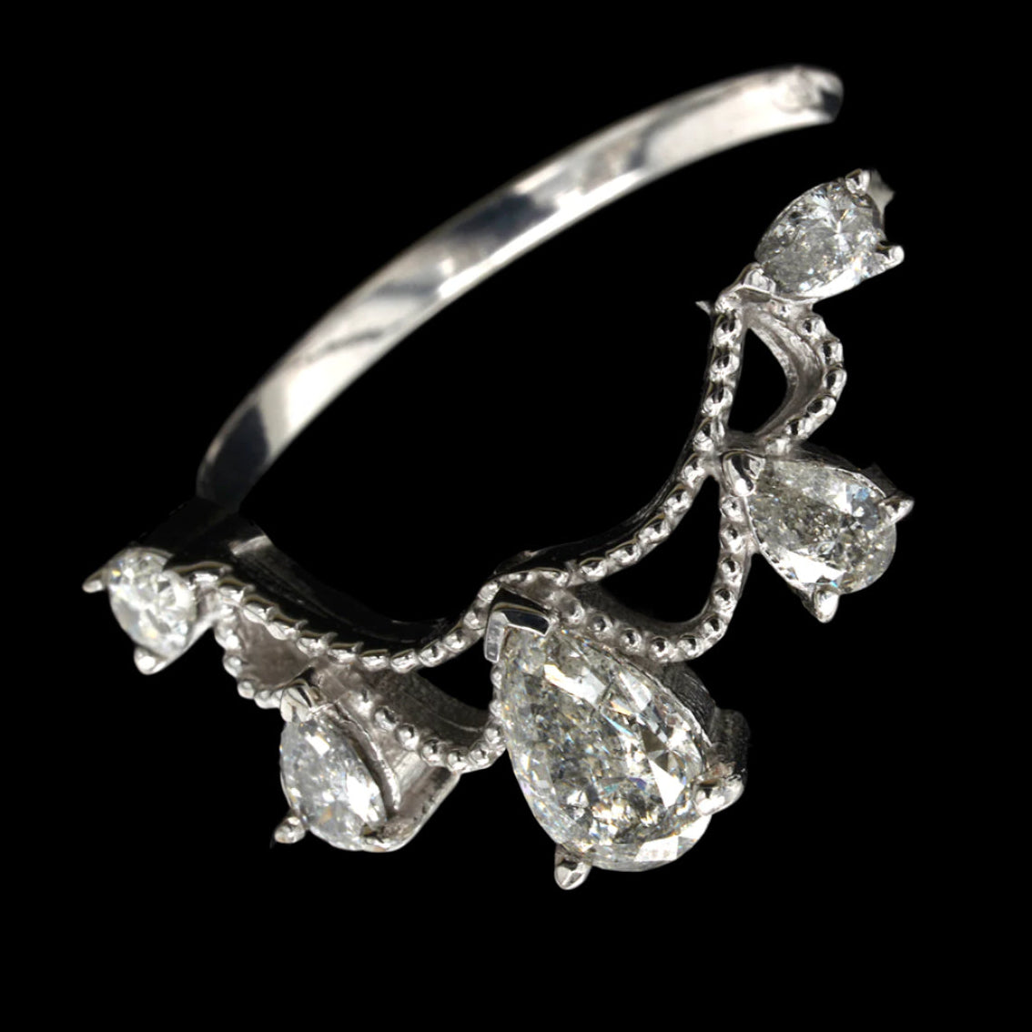An 18ct white gold engagement ring with pear-shaped diamonds set in delicate claw settings, intricate scroll work, and a central diamond prominently displayed.