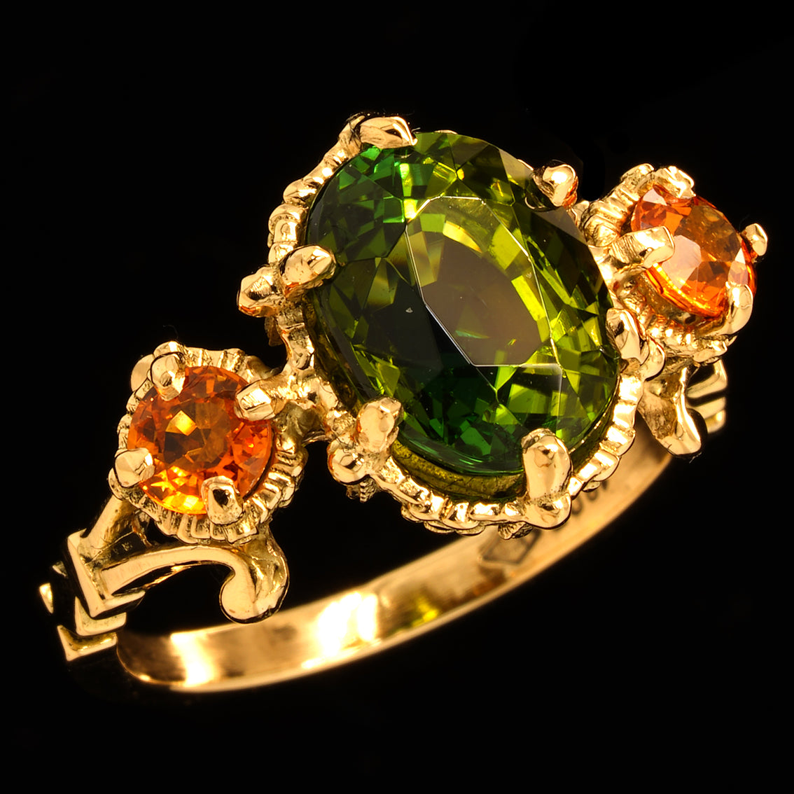 tourmaline and sapphire gold ring on a black background