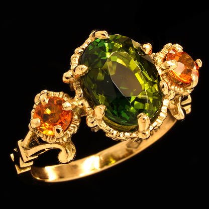 tourmaline and sapphire gold ring on a black background