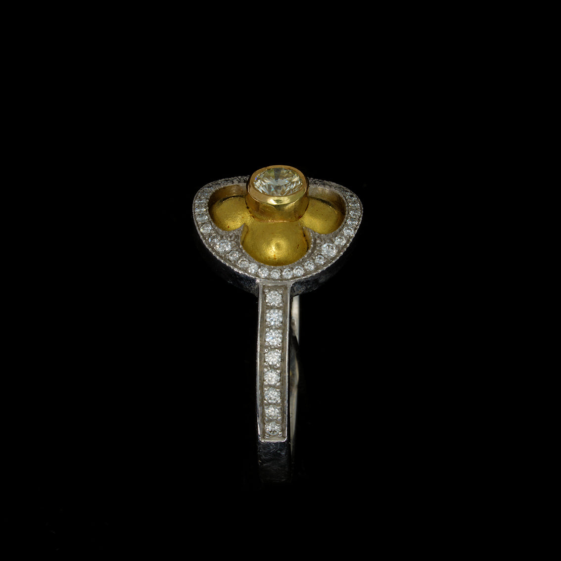 white and yellow gold 18 carat ring with a brilliant cut diamond, quatrefoil and halo of pave set diamonds
